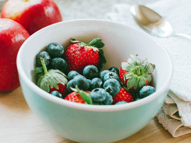 A porcelain bowl with strawberries and blueberries